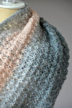 a close up of a knitted shawl on a mannequin