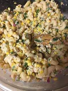 a bowl filled with macaroni and corn on top of a table