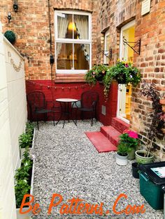 a small patio with tables and chairs next to a brick building