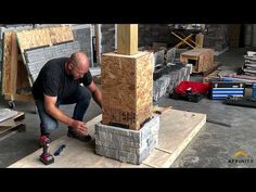 a man kneeling down next to a pile of wood