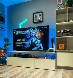 a flat screen tv sitting on top of a white entertainment center next to a book shelf