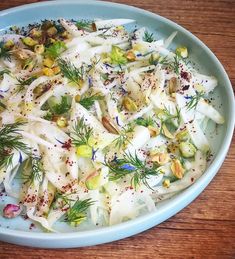 a blue bowl filled with food on top of a wooden table