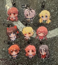 six key chains with anime characters on them sitting on a table next to each other