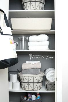 an organized closet with baskets and towels