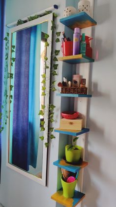 the shelves are painted blue and green with plants growing on them, along with other items