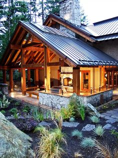 a house that is built into the side of a hill with rocks and plants around it