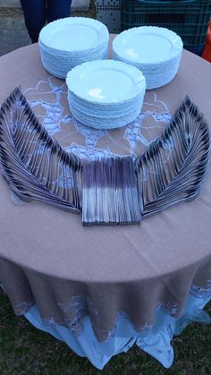 a table topped with plates and silverware on top of a cloth covered tablecloth