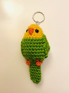 a crocheted keychain with a bird on it's back and eyes