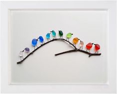 a group of colorful birds sitting on top of a branch in a white framed frame