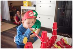 a young boy and an older man playing with plastic cups