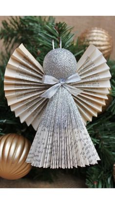 an ornament made out of book pages sitting on top of a christmas tree