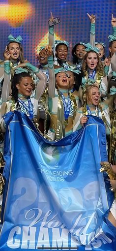 a group of cheerleaders posing for a photo with a blue and gold banner