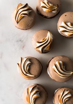 several cupcakes with frosting on them sitting on a table