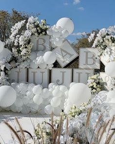 balloons and flowers decorate the entrance to a baby's first birthday party