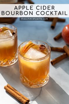 two glasses filled with apple cider bourbon cocktail next to cinnamon sticks and an apple