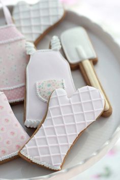 some decorated cookies are on a plate and ready to be eaten for the guests at a baby shower