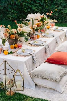 an outdoor table set with plates and place settings