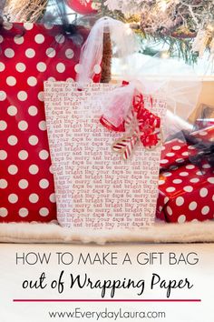 a red and white gift bag sitting on top of presents under a christmas tree with the words how to make a gift bag out of wrapping paper