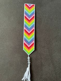 a multicolored tie with tassels hanging on the wall next to it