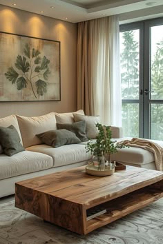 a living room with couches, coffee table and large window overlooking the trees outside