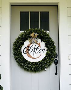 a white door with a green wreath on it and the words altton written in black