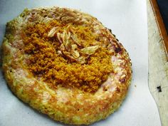 a close up of a pizza on a white table top with food crumbs