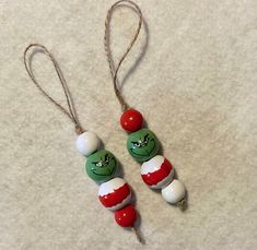 two green and red beads are hanging on a string with twine ends that have been made to look like candy canes