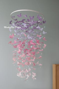 a wind chime with pink and purple butterflies hanging from it