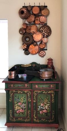 a green cabinet with pots and pans on it