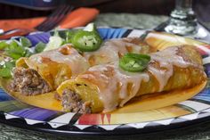 an enchilada is on a colorful plate