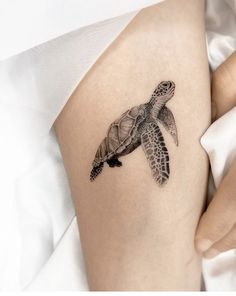 a woman's thigh with a turtle tattoo on it