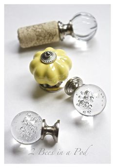 two yellow glass knobs are next to a corkscrew and bottle stopper