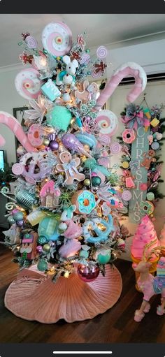 a pink and blue christmas tree decorated with candy canes, lollipops, candies and more