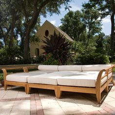 a wooden couch sitting on top of a brick patio