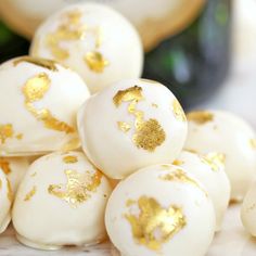 some white and gold decorated eggs sitting on a table next to a glass of champagne