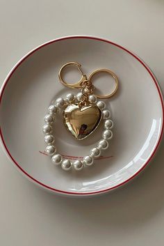 These keychains showcase a chunky puff heart metallic charm suspended from a chubby pearl beaded chain. With its unique design, this keychain adds a touch of style and sentiment to your everyday essentials. Carry your keys with a touch of love and flair, or attach them to your bag for a fashionable statement. The combination of the heart charm and the dainty pearls creates a harmonious blend of sophistication and playfulness. Please be aware that the charm is intentionally designed to have a bol Bag Charms Aesthetic, Key Chains Aesthetic, Classy Keychain, Pearl Keychain, Chains Aesthetic, Gold Keychain, Girly Car Accessories, Girly Car, Sewing Tutorials Free