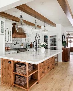 the instagram page shows an image of a kitchen with white cabinets and wood beams