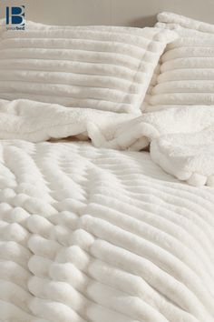 an unmade bed with white sheets and pillows