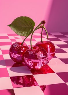 two shiny red cherries on a checkered table