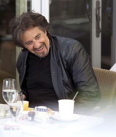 a man laughing while sitting at a table