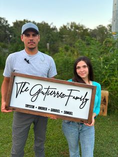 a man and woman standing next to each other holding a sign that says the gutter family