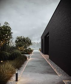 an empty walkway between two black buildings with lights on each side and trees in the background