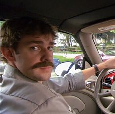 a man sitting in the driver's seat of a car