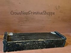 an old black box sitting on the floor in front of a sign that says crowe nest primitive shoppe