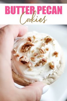 a person holding a cookie with white frosting and pecans on top, in front of the words butter pecan cookies