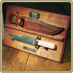 a wooden box with a knife inside of it