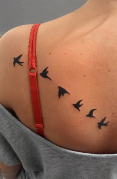 the back of a woman's shoulder with birds on it