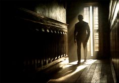 the silhouette of a man standing in an open doorway