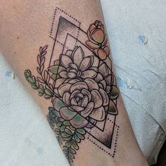 a woman's leg with a flower tattoo on her left arm and an arrow in the center