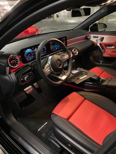 the interior of a sports car with red and black leather seats, steering wheel and dashboard